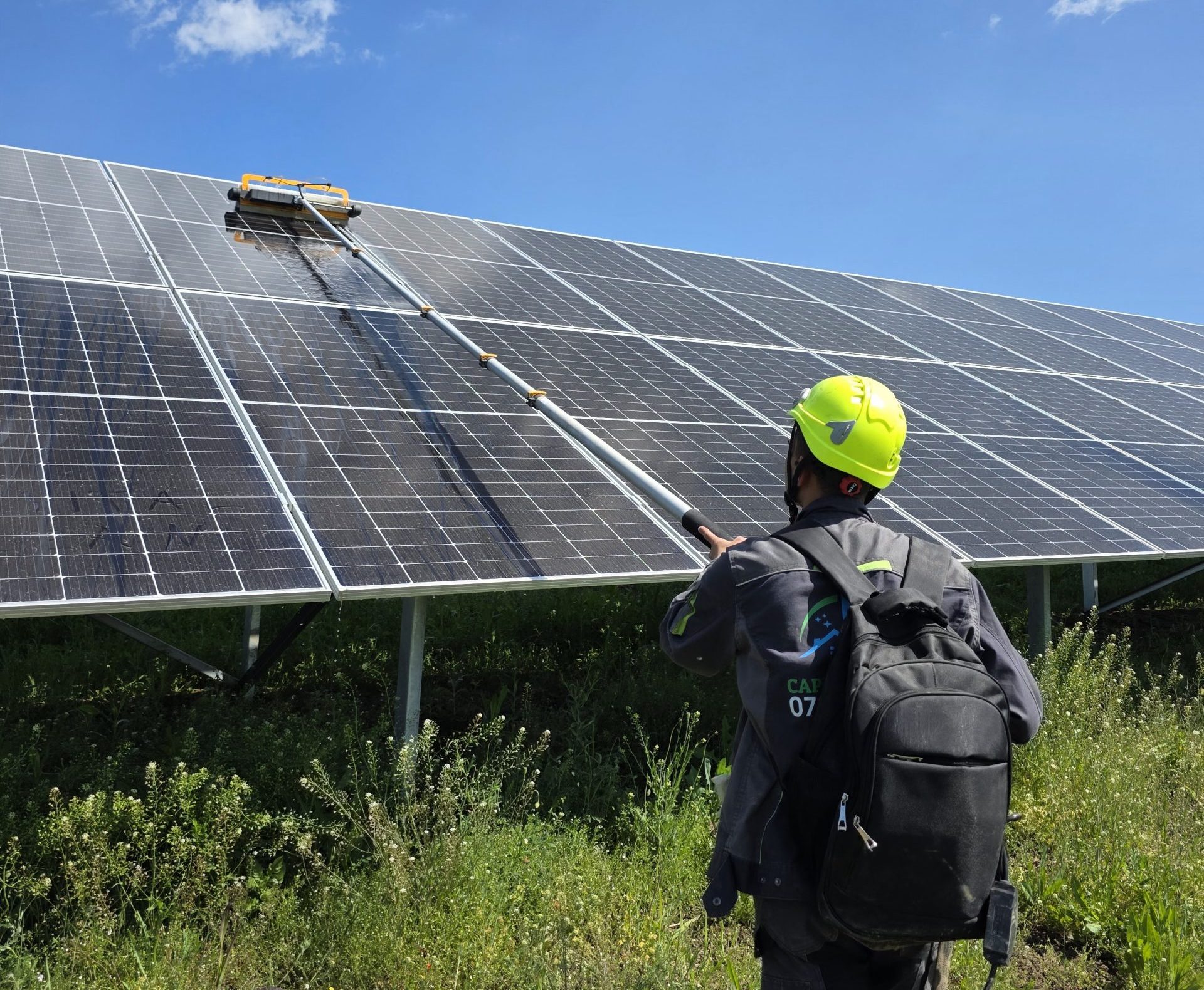 Spălarea rândurilor unui parc fotovoltaic la sol, cu perie rotativă pe coadă telescopică